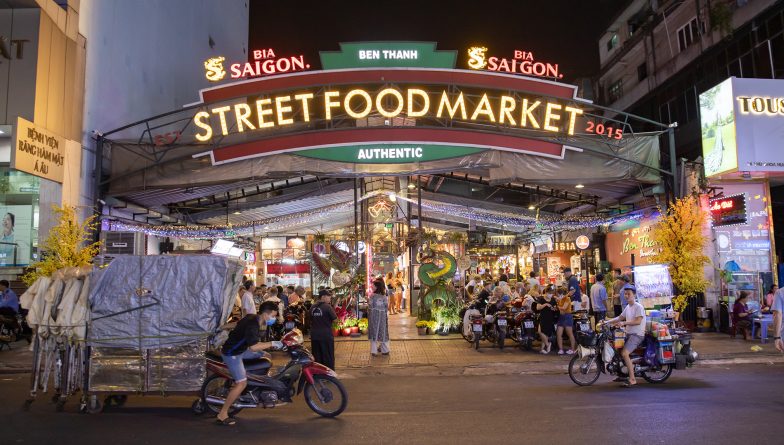 Entrance to the night market Ben Thanh, with people on the motorbikes